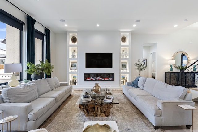 living room featuring a glass covered fireplace and recessed lighting