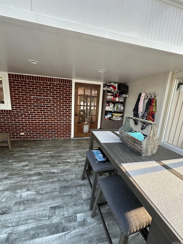 interior space with brick wall and wood finished floors