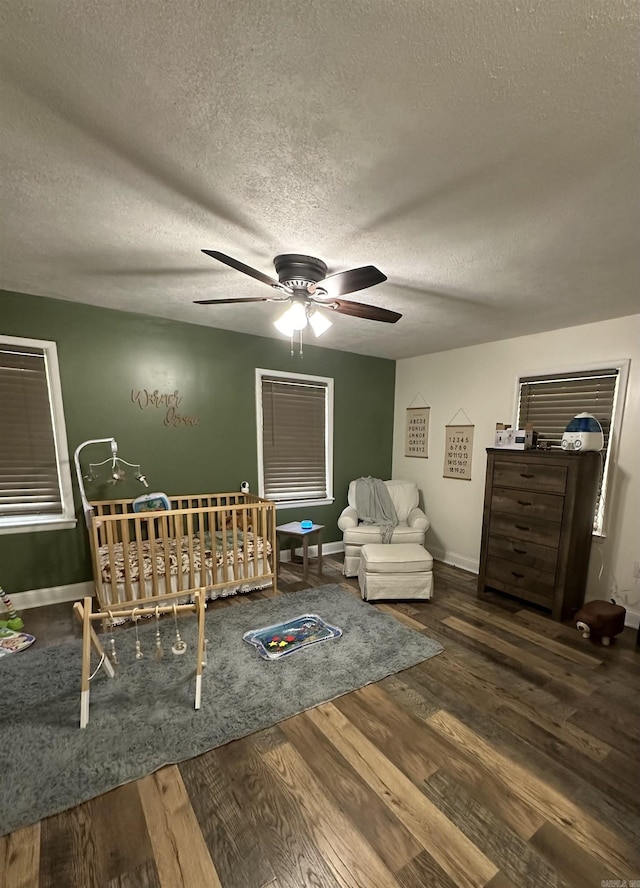 unfurnished bedroom with a textured ceiling, baseboards, and wood finished floors