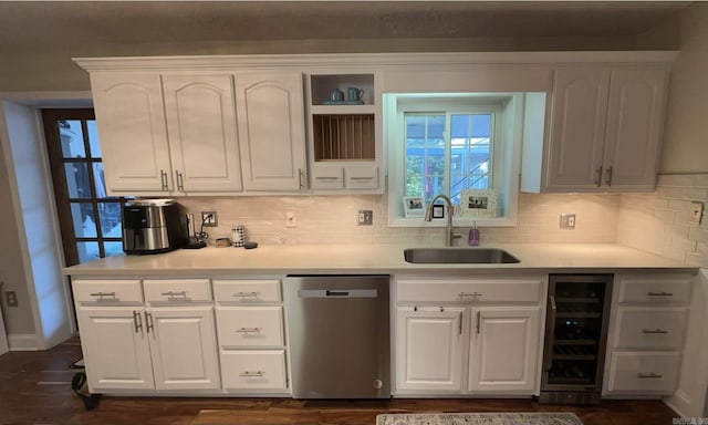 kitchen with a sink, beverage cooler, white cabinets, and stainless steel dishwasher