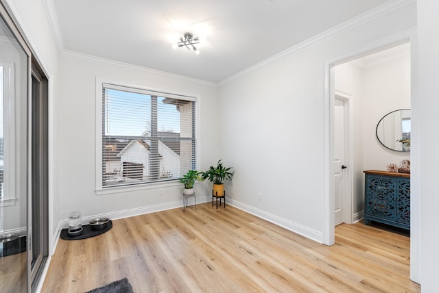 spare room with crown molding, baseboards, and wood finished floors