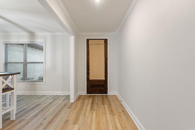 interior space featuring light wood-style floors, baseboards, and crown molding