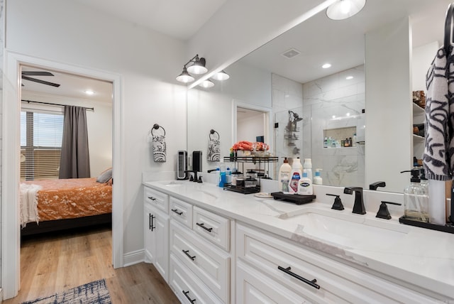 full bath featuring a stall shower, visible vents, a sink, and wood finished floors