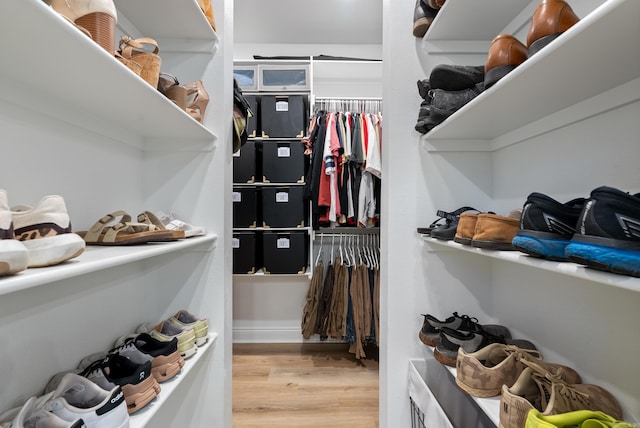 walk in closet with wood finished floors