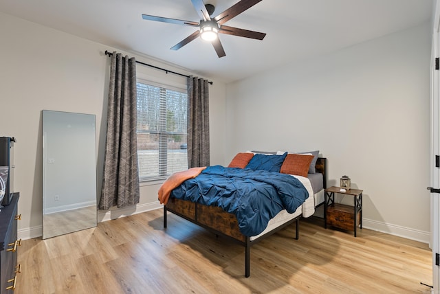 bedroom featuring baseboards, a ceiling fan, and light wood-style floors