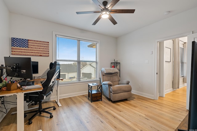 office area with light wood-style floors, ceiling fan, and baseboards