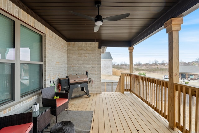 wooden terrace featuring grilling area and a ceiling fan