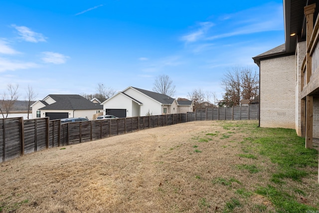 view of yard with a fenced backyard and a residential view