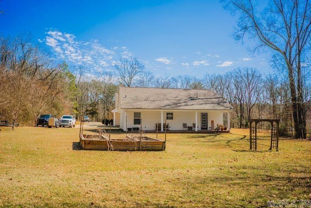 rear view of house featuring a garden and a lawn