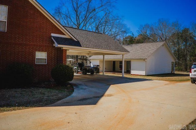 view of home's exterior featuring an attached carport, concrete driveway, and brick siding