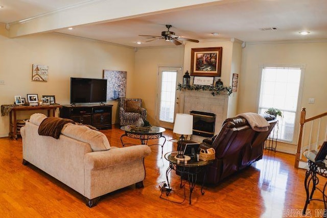 living room featuring ornamental molding, a fireplace, and wood finished floors