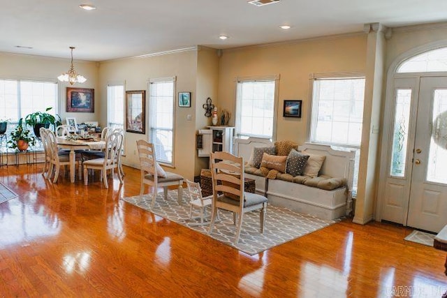 living room featuring visible vents, crown molding, and wood finished floors