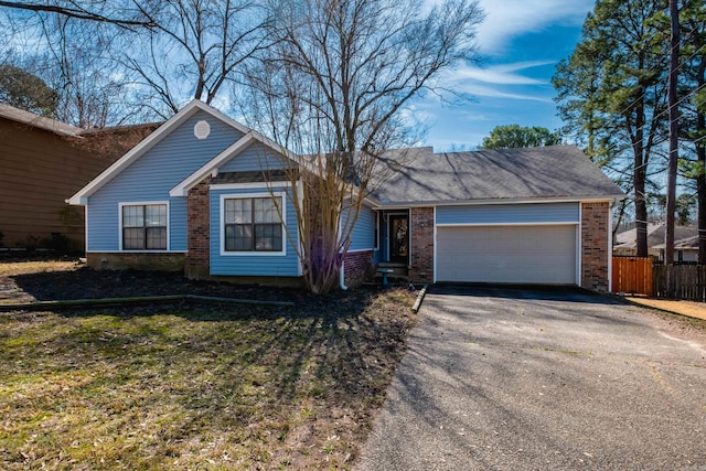 ranch-style home featuring a garage, driveway, brick siding, and fence