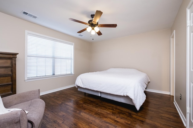 bedroom featuring dark wood-style floors, a ceiling fan, visible vents, and baseboards