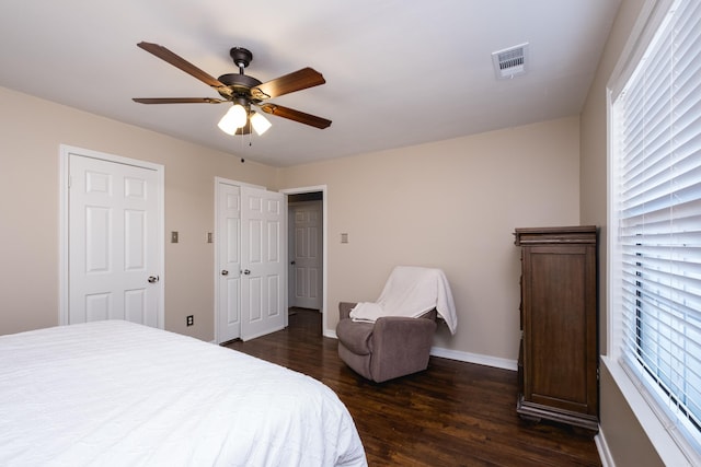 bedroom featuring dark wood-type flooring, visible vents, baseboards, and a ceiling fan