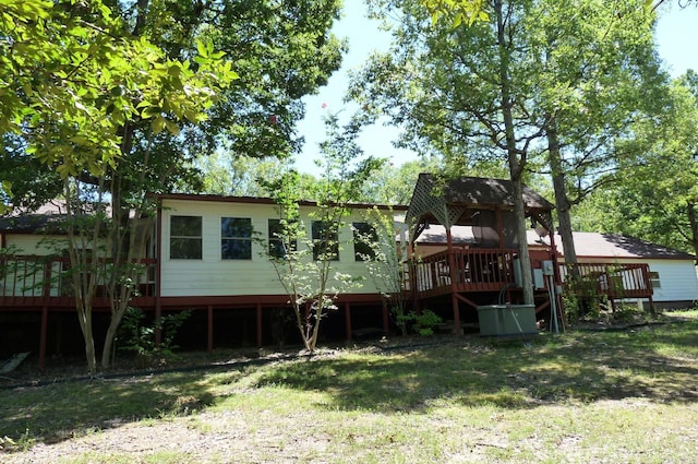 back of property featuring a lawn and a wooden deck