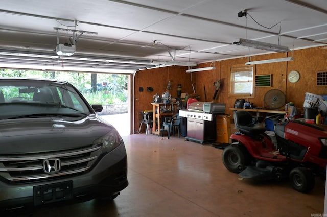 garage featuring wood walls and a garage door opener