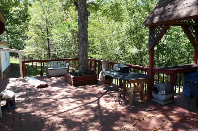 deck with a forest view and grilling area