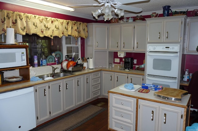 kitchen with light countertops, white cabinetry, a sink, a textured ceiling, and white appliances