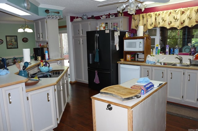 kitchen with dark wood-style floors, a center island, ornamental molding, a sink, and black appliances