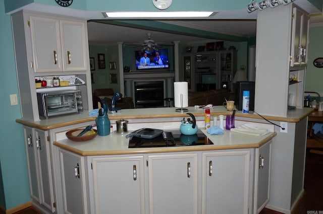 kitchen with light countertops, ornamental molding, a fireplace, and white cabinetry