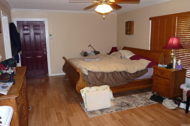 bedroom featuring ornamental molding, ceiling fan, baseboards, and wood finished floors