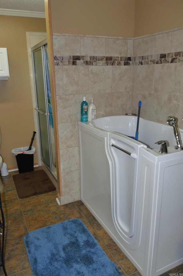 full bath with ornamental molding, a stall shower, a garden tub, and tile walls