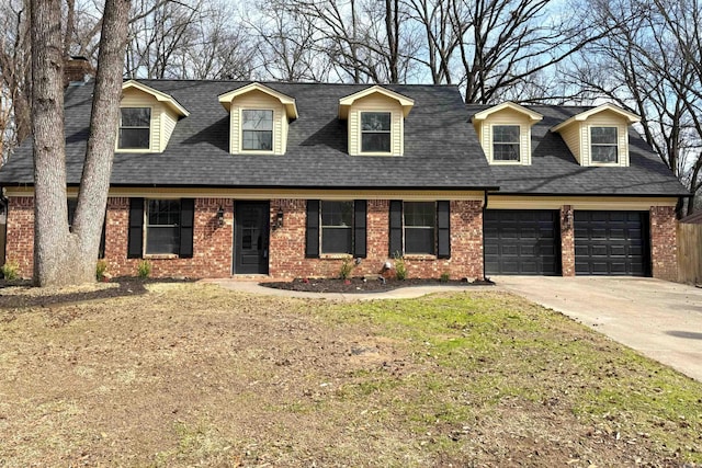 cape cod house featuring a garage, concrete driveway, brick siding, and roof with shingles