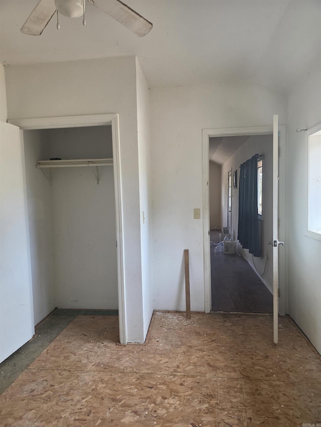 unfurnished bedroom with lofted ceiling, a closet, and ceiling fan