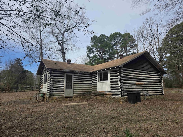 view of front of house with a chimney and log siding