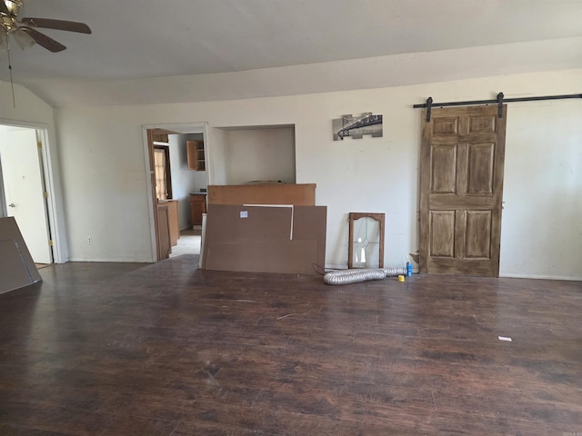 unfurnished living room featuring a ceiling fan, wood finished floors, and a barn door