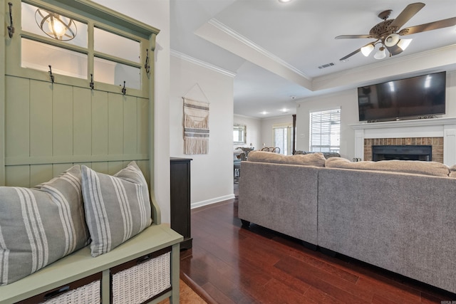 living area featuring ornamental molding, dark wood-style flooring, a raised ceiling, and visible vents