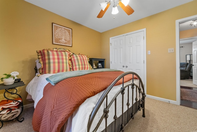 carpeted bedroom with ceiling fan, baseboards, and a closet