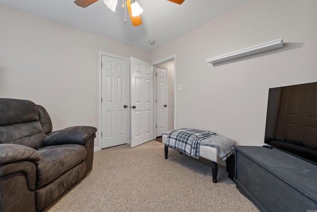 living area with ceiling fan and light colored carpet