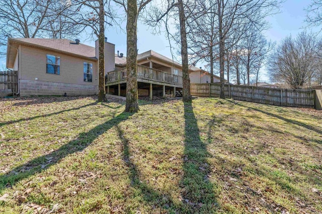 back of property with a fenced backyard, a yard, a chimney, and a wooden deck