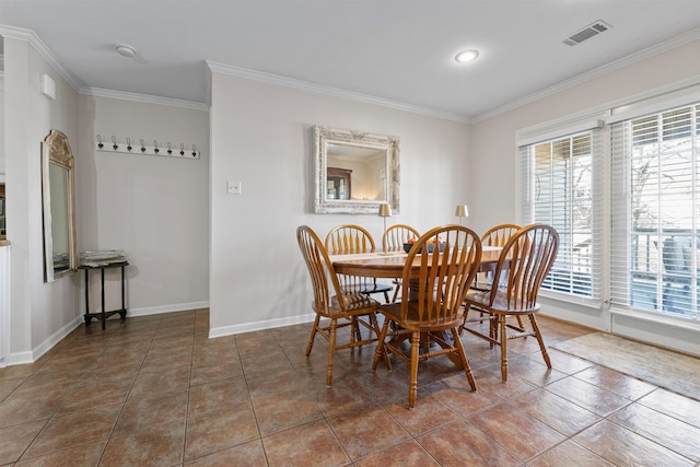 tiled dining room featuring baseboards, visible vents, and ornamental molding