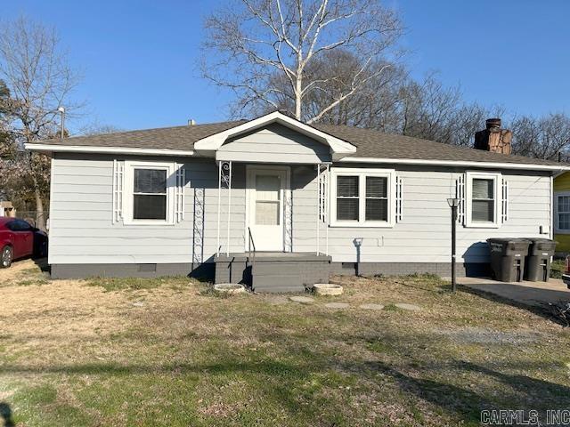 bungalow-style home with crawl space, a chimney, and a front lawn