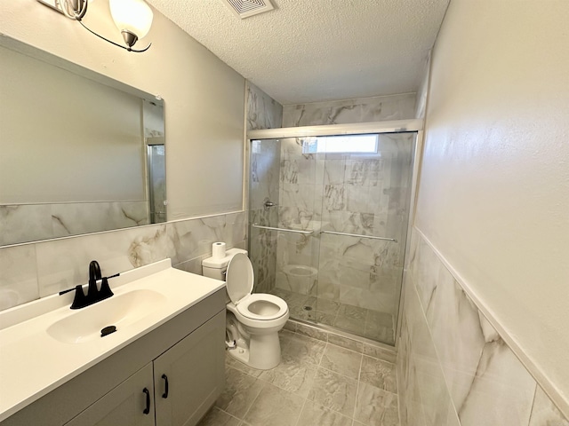 full bath with visible vents, toilet, a stall shower, a textured ceiling, and vanity