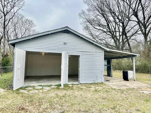 garage featuring a garage and fence