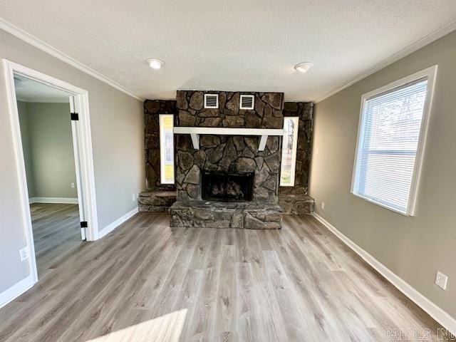 unfurnished living room featuring crown molding, a fireplace, a textured ceiling, and wood finished floors