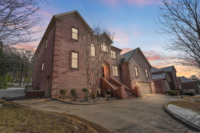 view of front of home with driveway, brick siding, and an attached garage