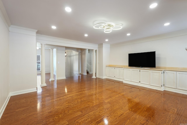 unfurnished living room with light wood finished floors, recessed lighting, ornate columns, ornamental molding, and baseboards