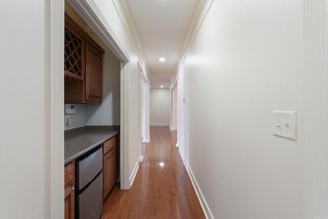 corridor with light wood-type flooring, baseboards, and recessed lighting