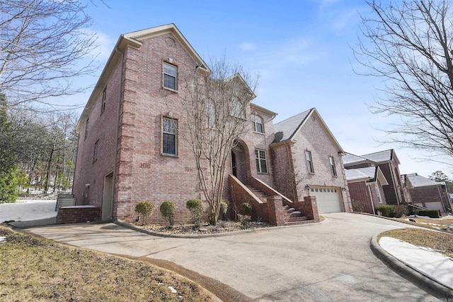 view of front of property with concrete driveway, brick siding, and an attached garage