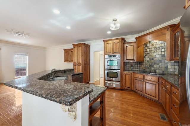 kitchen with a breakfast bar, a sink, visible vents, appliances with stainless steel finishes, and a warming drawer