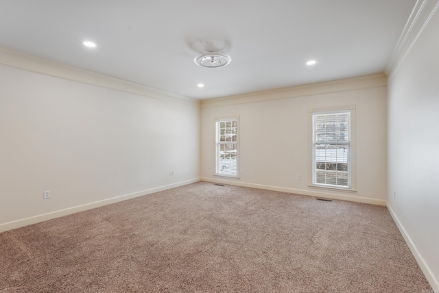 empty room with light carpet, plenty of natural light, baseboards, and crown molding