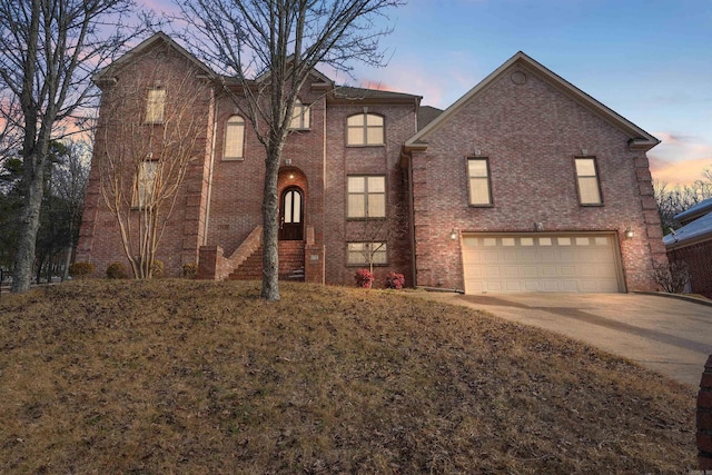 view of front of home with concrete driveway, brick siding, and an attached garage