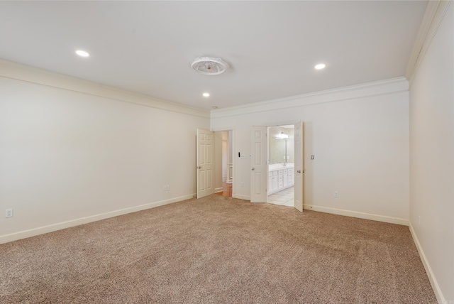 empty room featuring recessed lighting, light colored carpet, crown molding, and baseboards