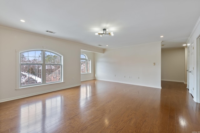 unfurnished room featuring recessed lighting, wood finished floors, visible vents, baseboards, and ornamental molding