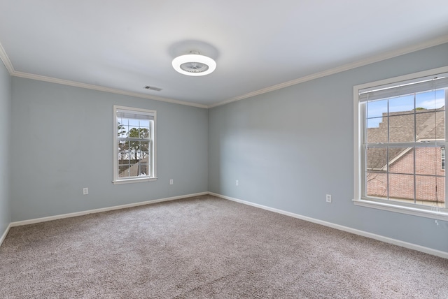 carpeted empty room featuring visible vents, baseboards, and crown molding